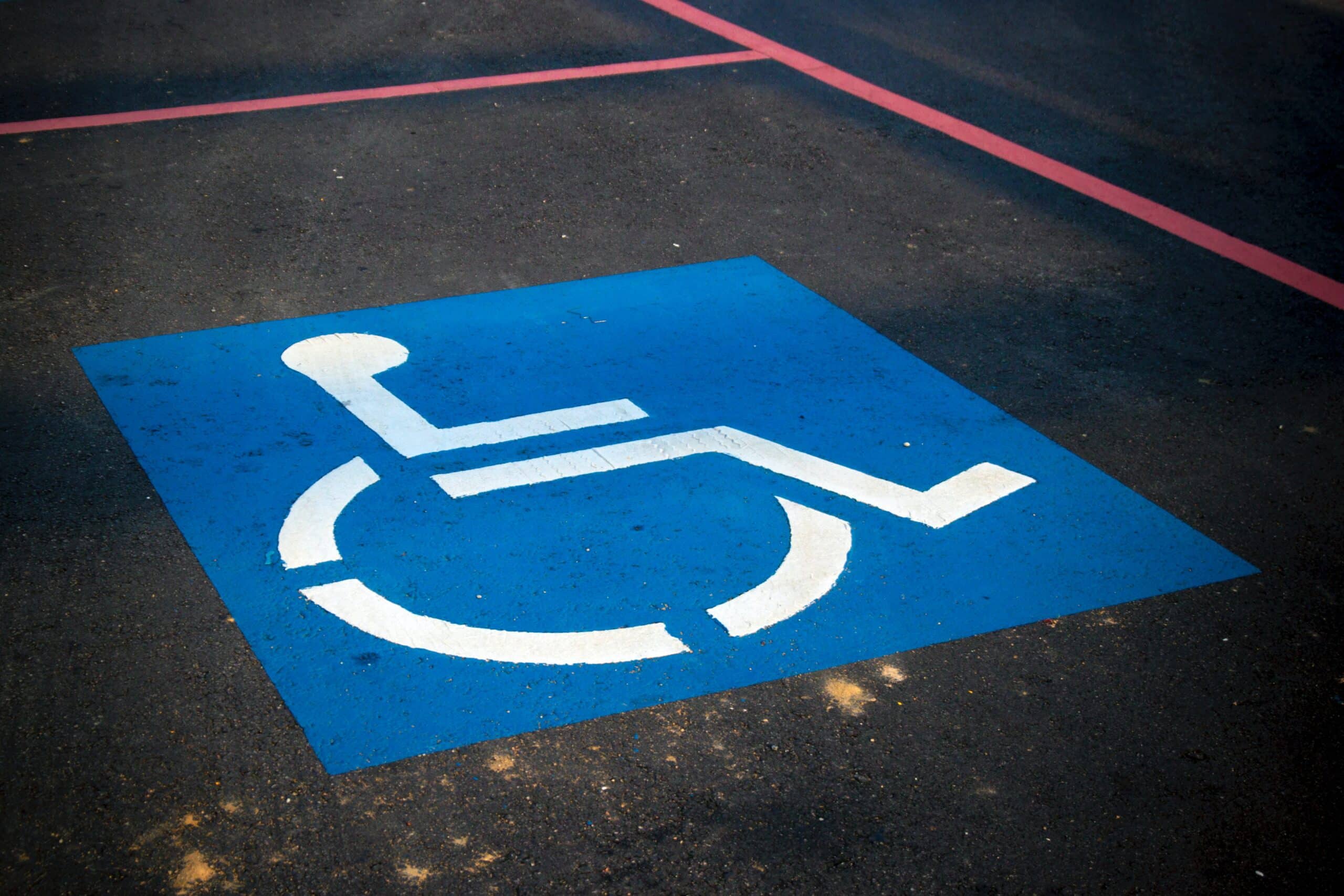 A blue and white handicap logo in a parking spot, representing disability benefits laws in Canada