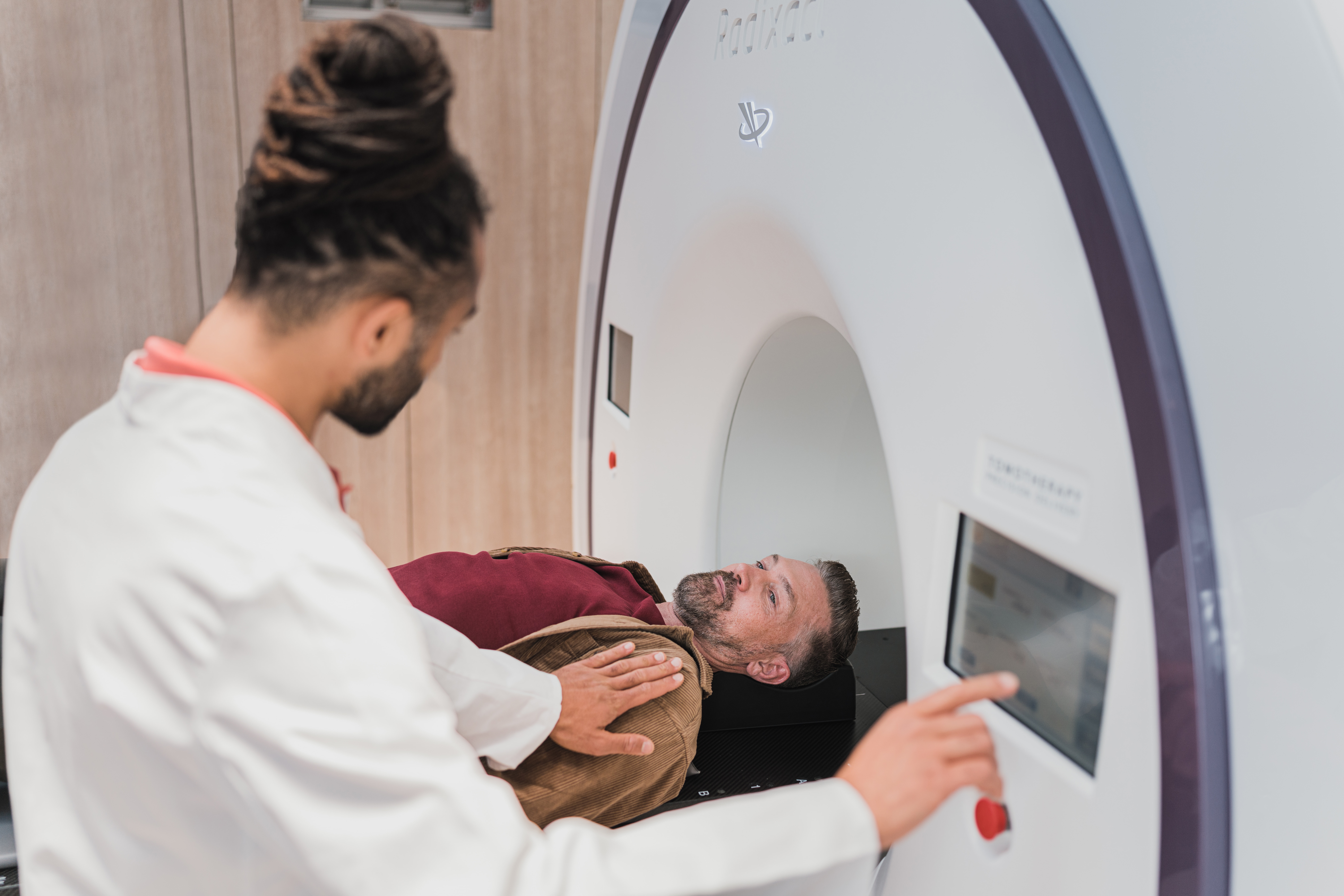 An MRI tech reassuring a patient on the MRI device, representing short-term and long-term disability benefit claims in Ontario