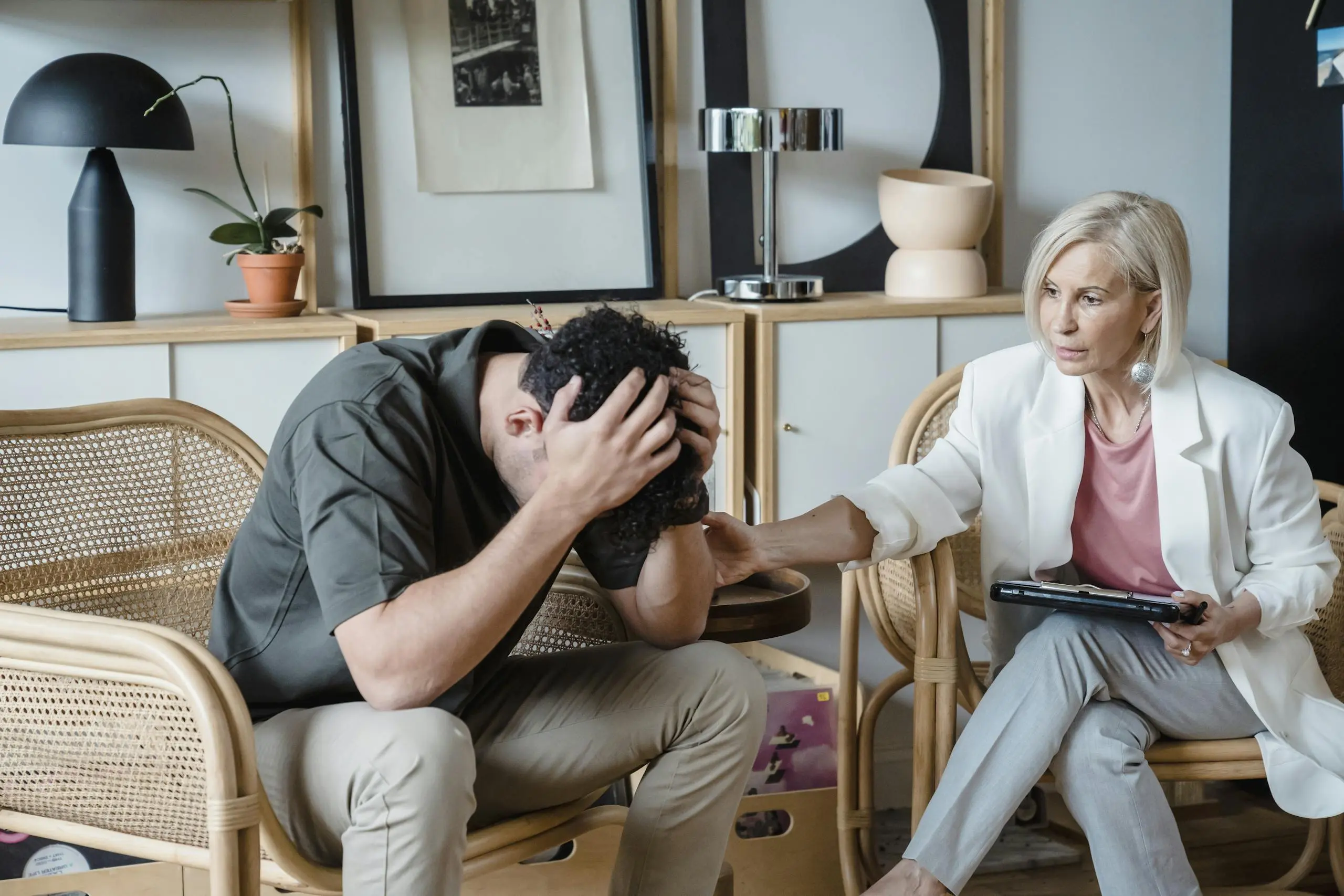 A supportive therapist provides comfort during a counseling session in a cozy office.