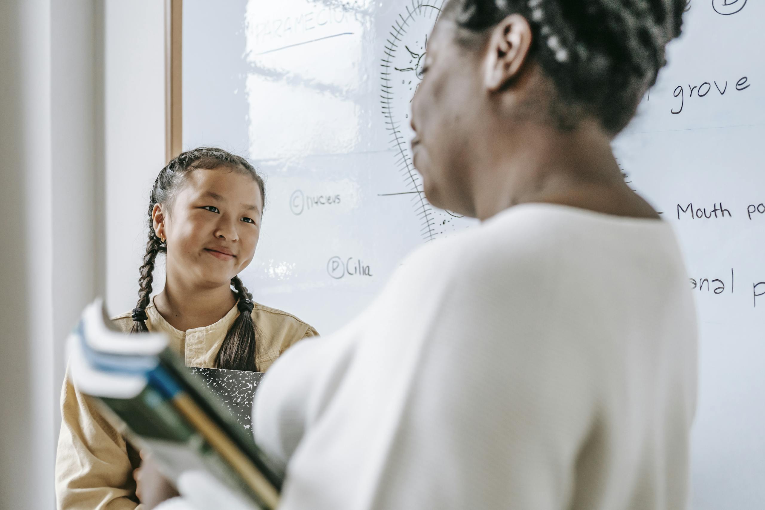 A teacher and a student interact in a classroom setting, fostering learning and engagement.