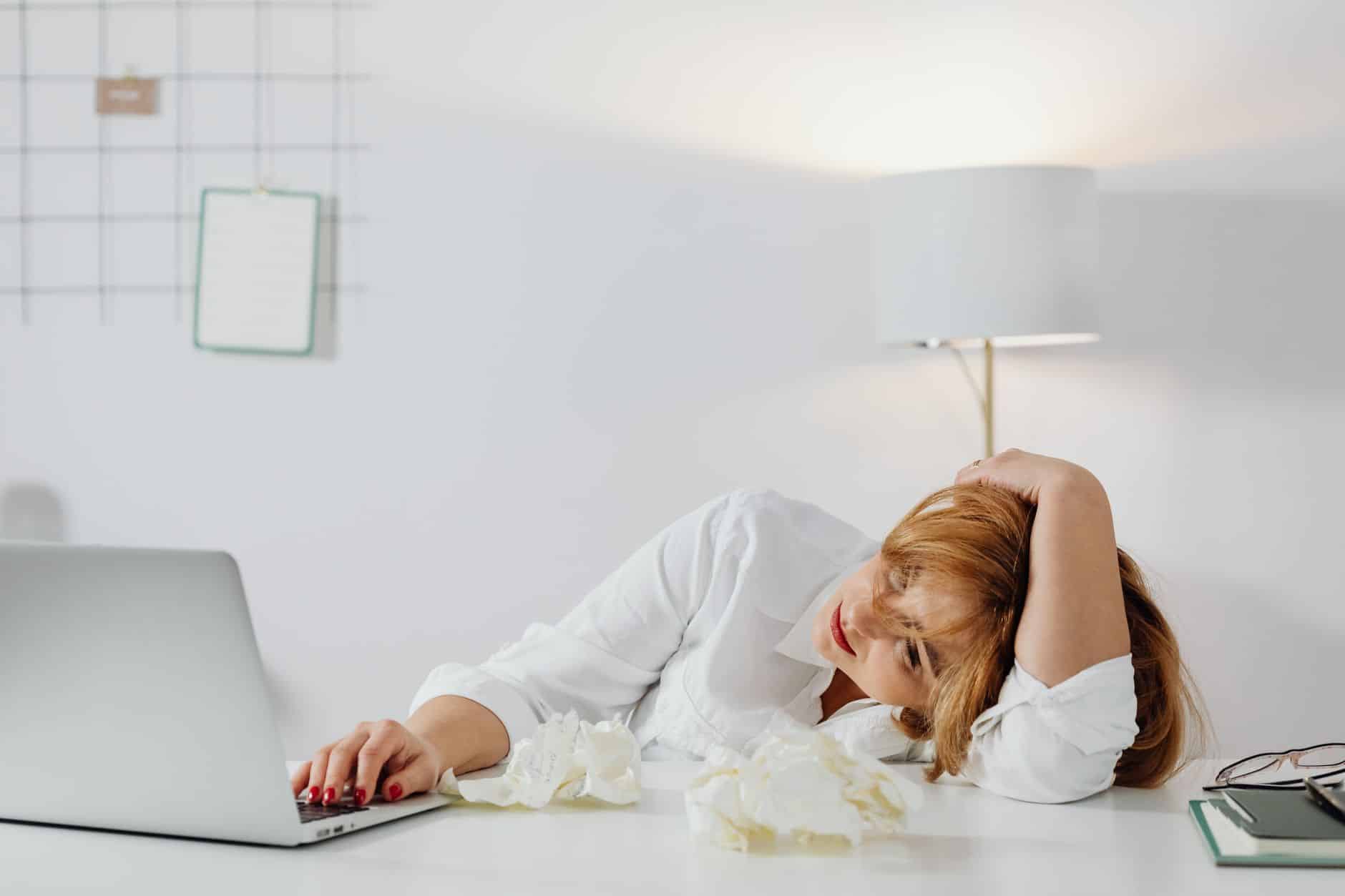 a bored woman looking at the macbook laptop